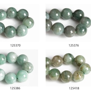 May include: Four strands of green jade beads, each strand is a different shade of green. The beads are round and smooth. The strands are labeled with the numbers 125370, 125376, 125386, and 125418.