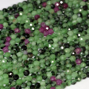 May include: A strand of green and pink gemstone beads. The beads are faceted and have a rough, textured surface.