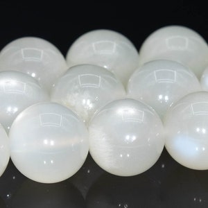 May include: A strand of white moonstone beads. The beads are round and smooth, with a subtle iridescent sheen.
