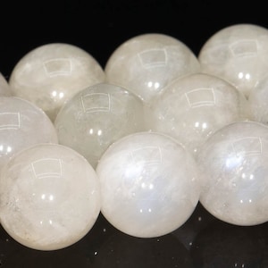 May include: A strand of white moonstone beads, each bead is a smooth sphere with a subtle iridescent sheen.