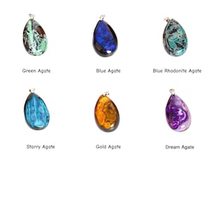 Puede incluir: Seis colgantes de piedras preciosas en varios colores, incluyendo verde, azul y dorado. Cada piedra en forma de l&aacute;grima tiene una fianza plateada. El texto debajo de cada colgante identifica el tipo de piedra: &Aacute;gata verde, &Aacute;gata azul, &Aacute;gata rodonita azul, &Aacute;gata estrellada, &Aacute;gata dorada y &Aacute;gata de ensue&ntilde;o.
