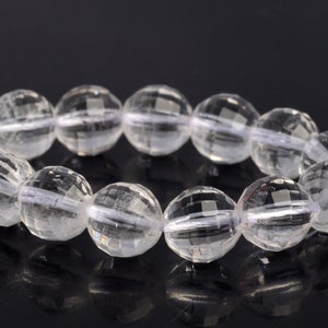May include: A strand of clear faceted crystal beads. The beads are round and have a smooth, polished finish.