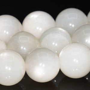 May include: A strand of white gemstone beads. The beads are round and smooth, with a slight iridescent sheen.