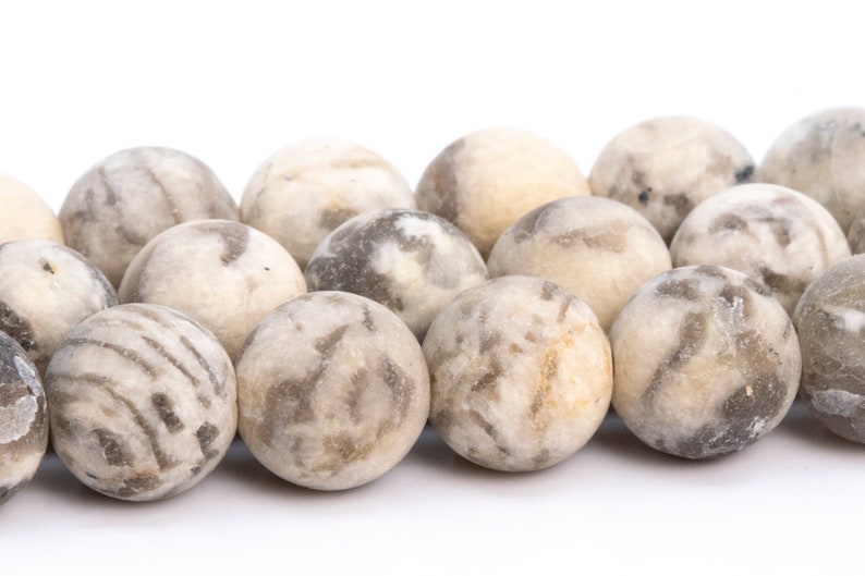 May include: A strand of round, white and gray agate beads. The beads have a marbled pattern and are smooth and polished.