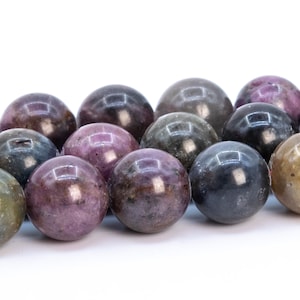 May include: A strand of round, multi-colored gemstone beads. The beads are a mix of purple, green, and brown with a shiny, polished finish.