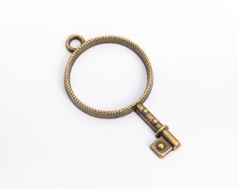 Könnte beinhalten: Ein goldfarbener Schlüsselanhänger mit einer runden, verzierten Schlaufe oben und einem detaillierten Schlüssel-Design. Der Anhänger ist perfekt, um Schmuck oder Bastelarbeiten einen Vintage-Touch zu verleihen.