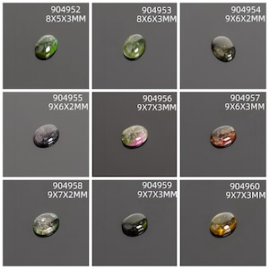 May include: Nine oval-shaped gemstones in various colors, including green, black, and brown. Each stone is displayed on a dark surface with a white label indicating its dimensions in millimeters. The gemstones vary in size, with the largest measuring 9x7x3mm.