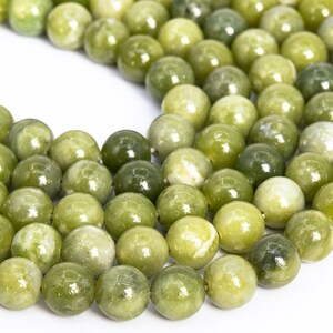 May include: A strand of round, green jade beads. The beads are smooth and polished, with a slight variation in colour.
