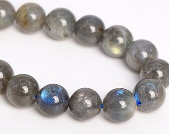 May include: A strand of round, gray labradorite beads with iridescent blue and green flashes. The beads are strung on a blue cord.