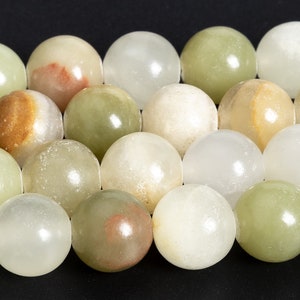 May include: A strand of round, smooth, green, white, and brown gemstone beads. The beads are polished and have a natural, organic look.
