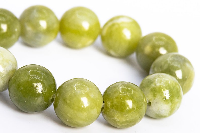 May include: A bracelet made of round, green jade beads. The beads are polished and have a smooth, glossy finish.