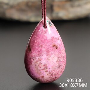 May include: A pink teardrop-shaped pendant with a maroon cord. The pendant is a polished stone with dark brown and white inclusions. The dimensions are 30x18x7mm.