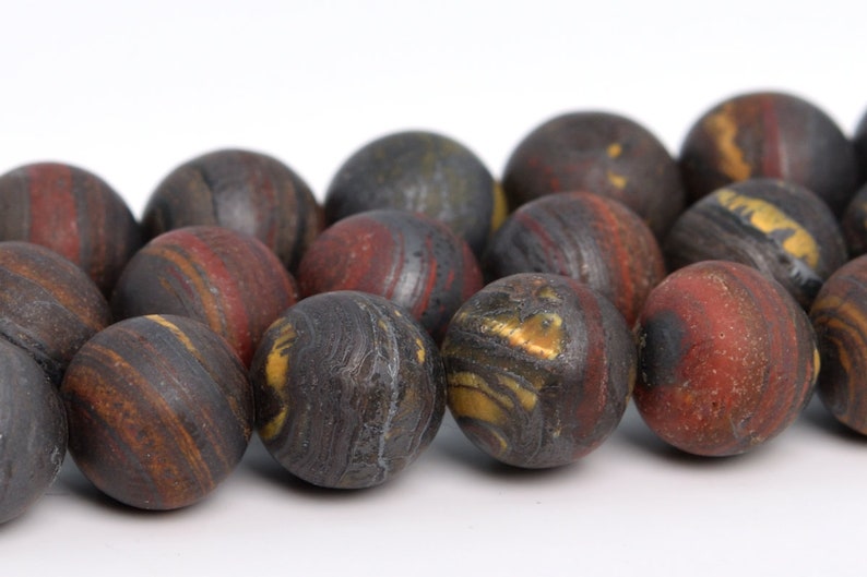 May include: A strand of round, dark brown, red, and gold gemstone beads. The beads have a swirling, marbled pattern.