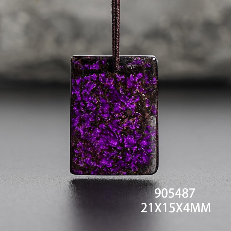Op de afbeelding: Rechthoekige hanger met een levendig paars en zwart gespikkeld patroon, bevestigd aan een bruin koord. De afmetingen zijn 21mm x 15mm x 4mm. De hanger heeft een gepolijste, glanzende afwerking. De tekst "905487" is zichtbaar.