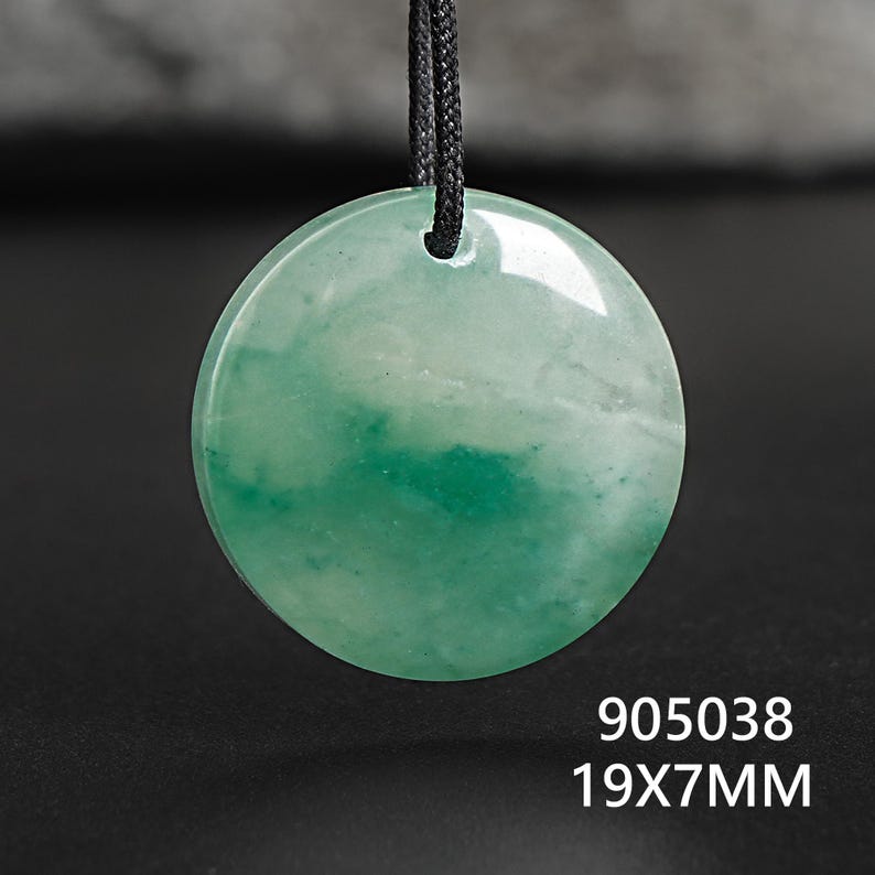 Pu&ograve; includere: Ciondolo rotondo in giada verde con cordino nero. Il ciondolo misura 1,9 cm di diametro e 0,7 cm di spessore. La superficie presenta un aspetto marmorizzato con varie tonalit&agrave; di verde. Il testo "905038" e "19X7MM" sono visibili.
