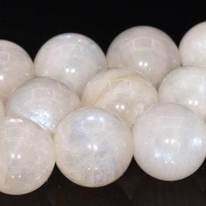 May include: A strand of white moonstone beads, each bead is a smooth sphere with a subtle iridescent sheen.