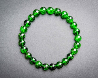 Puede incluir: Un brazalete de piedras preciosas verdes con cuentas redondas.