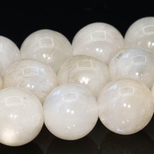 May include: A strand of white moonstone beads, each bead is a smooth, round sphere.
