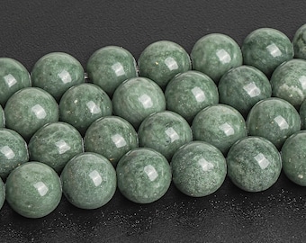 May include: A strand of round, green jade beads. The beads are smooth and polished, with a subtle marbling effect.