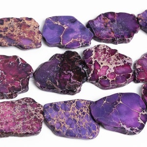May include: A strand of purple and brown jasper beads. The beads are irregularly shaped and have a marbled pattern.