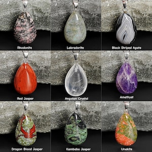 Puede incluir: Nueve colgantes de piedras preciosas con aros plateados. Las piedras incluyen Rodonita, Labradorita, &Aacute;gata Negra Rayada, Jaspe Rojo, Cristal Angole&ntilde;o, Amatista, Jaspe de Sangre de Drag&oacute;n, Jaspe Kambaba y Unakita. Cada piedra tiene forma de l&aacute;grima.