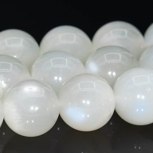 Könnte beinhalten: Eine Kette aus weißen Mondsteinperlen. Die Perlen sind rund und glatt, mit einem dezenten irisierenden Schimmer.