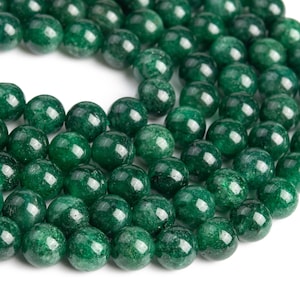 May include: A strand of round, green jade beads. The beads are smooth and polished, with a slight sparkle.