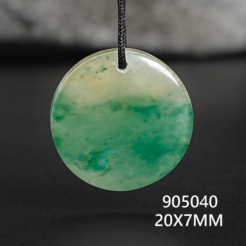 Pu&ograve; includere: Un ciondolo rotondo verde e bianco, con un cordino nero. Il ciondolo ha un aspetto marmorizzato con sfumature verdi e bianche. Il testo "905040 20X7MM" &egrave; visibile in basso nell'immagine.