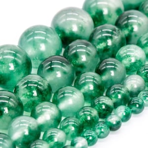 May include: A strand of green jade beads, each bead is round and polished, with a translucent green color and subtle white marbling.