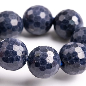 Peut inclure: Un collier de perles de pierres précieuses bleu foncé avec un motif hexagonal facetté. Les perles sont enfilées sur un cordon bleu.