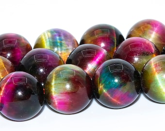 Puede incluir: Una hebra de cuentas redondas de piedras preciosas iridiscentes. Las cuentas son una mezcla de rojo oscuro, verde, dorado y negro con una superficie brillante y reflectante.