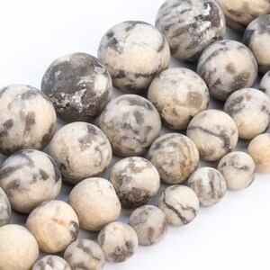 May include: A strand of round, white and gray agate beads. The beads are smooth and have a natural, marbled pattern.