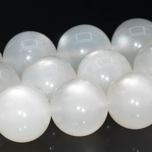 May include: A strand of white moonstone beads. The beads are round and smooth, with a subtle shimmer.