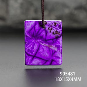 Op de afbeelding: Een rechthoekige paarse hanger met donkere adering, hangend aan een bruin koord. De hanger meet ongeveer 1,8 x 1,5 x 0,4 cm. De afbeelding toont ook de productcode en afmetingen.