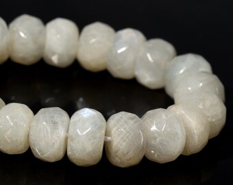 May include: A strand of polished, off-white moonstone beads. Each bead is a rounded, irregular shape with a subtle, iridescent sheen. The beads are strung together, creating a necklace or bracelet.