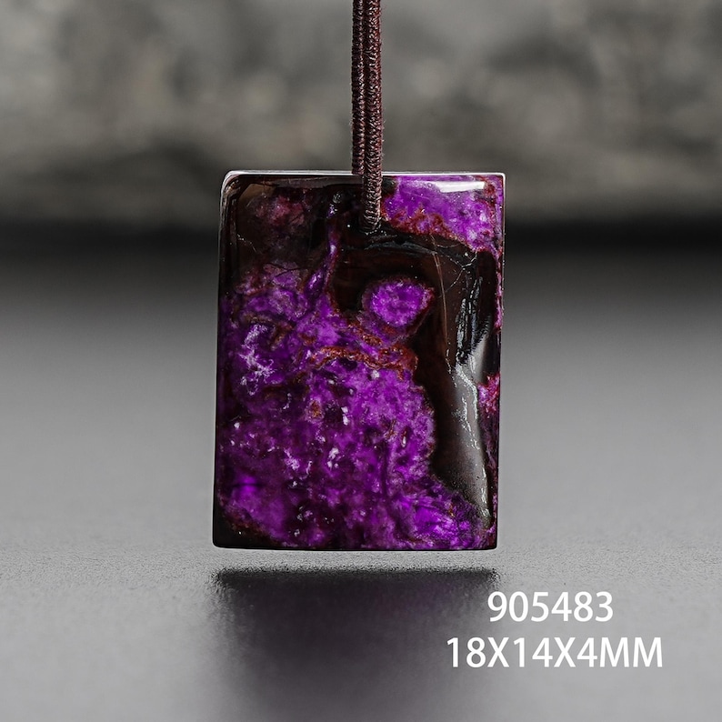 Op de afbeelding: Een rechthoekige hanger met een levendig paars en donkerbruin gemarmerd patroon. De hanger is opgehangen aan een bruin koord. De afmetingen zijn 1,8x1,4x0,4cm. De tekst "905483" is zichtbaar.