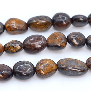 Könnte beinhalten: Eine Kette aus braunen und schwarzen Edelsteinperlen. Die Perlen sind glatt und oval geformt.