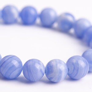 Puede incluir: Un brazalete de cuentas de &aacute;gata azul con un patr&oacute;n de m&aacute;rmol azul claro y blanco.