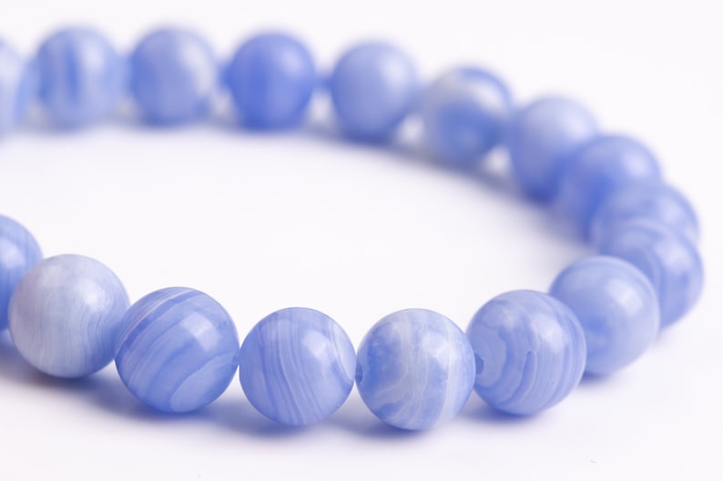Puede incluir: Un brazalete de cuentas de &aacute;gata azul con un patr&oacute;n de m&aacute;rmol azul claro y blanco.