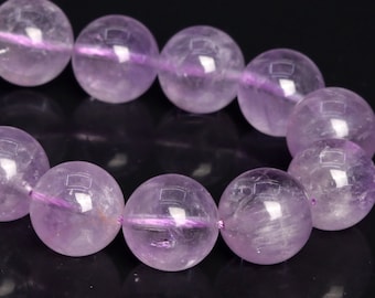 May include: A strand of light purple amethyst beads, each bead is round and smooth. The beads are strung together with a thin, clear thread.