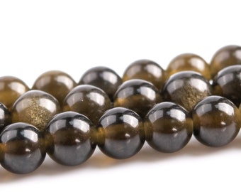 May include: Close-up of a strand of polished, round beads. The beads are a mix of dark, translucent colors, including shades of brown and gold. The beads have a glossy finish and are strung together, ideal for jewelry making.