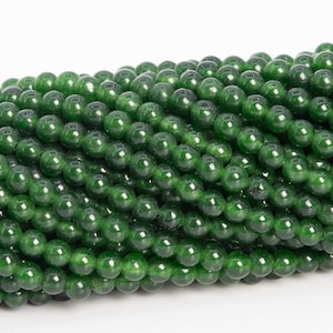 May include: A strand of round, green jade beads. The beads are smooth and polished, with a slight sheen.