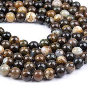 May include: A strand of round, brown, black and white agate beads. The beads have a natural, polished finish.