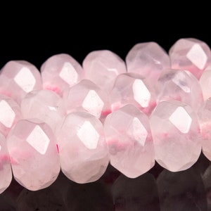 Puede incluir: Una hebra de cuentas de cuarzo rosa facetadas. Las cuentas son de color rosa pálido y tienen un acabado liso y pulido.