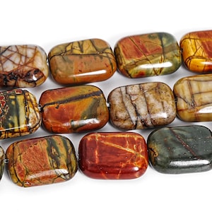 May include: Close-up of a strand of rectangular, polished gemstone beads. The beads display a variety of earthy tones, including brown, red, green, and yellow, with intricate veining patterns. The beads are strung together, ready for jewelry making.