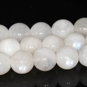 May include: A strand of white moonstone beads. The beads are round and smooth, with a slight iridescent sheen.