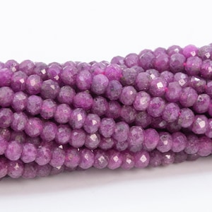 May include: A strand of purple faceted gemstone beads. The beads are round and have a slightly irregular shape.