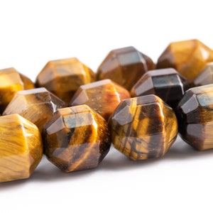 May include: A strand of faceted tiger's eye beads in shades of brown, gold, and black. The beads are arranged in a row and have a glossy finish.