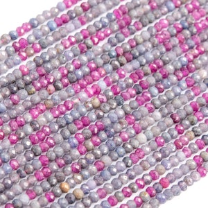 Peut inclure: Un brin de perles de pierres précieuses facettées dans des tons de rose et de bleu. Les perles sont petites et rondes, et elles sont enfilées sur un fil transparent.