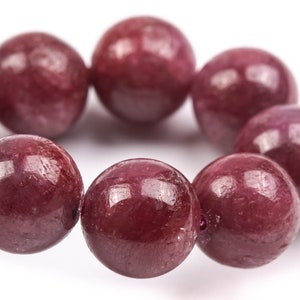 May include: A bracelet made of round, deep red gemstone beads.
